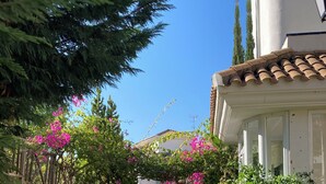 A stone pathway leading to a building with a tiled roof and white walls.
