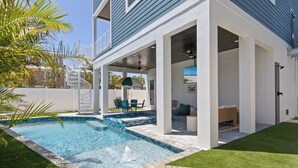 A modern house with a swimming pool, outdoor seating, and a covered patio area. - Take A Dip- Luxury 6 bedrooms, close to beach, pool and spa!! (Bradenton Beach)