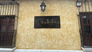 A building facade with a sign reading "El Alquimista Cafe Bistro". - Enchanted Forest (Antigua Guatemala)
