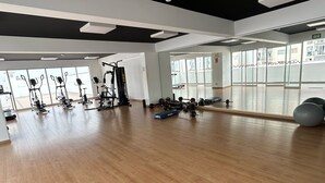 A spacious gym with wooden flooring, various exercise equipment, and large windows providing natural light. - Beautiful Apartment in Lima (Lima)