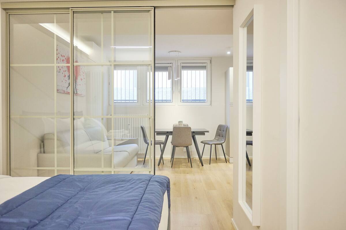 Une chambre à coucher avec un lit, un bureau et deux chaises.