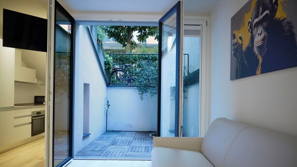 Une cuisine moderne avec une porte-fenêtre coulissante donnant sur un balcon.