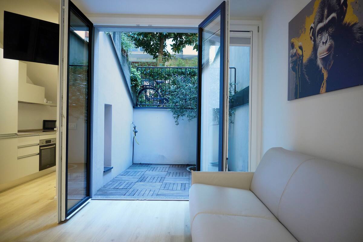 Une cuisine moderne avec une porte-fenêtre coulissante donnant sur un balcon.