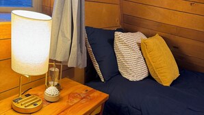 A cozy room with a wooden bed, a small table with a lamp, and a rug. - Cozy A-frame Cabin with WiFi and AC in charming Antelope (Antelope)