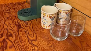 A coffee maker, two patterned mugs, and two clear glasses on a wooden surface. - Cozy A-frame Cabin with WiFi and AC in charming Antelope (Antelope)
