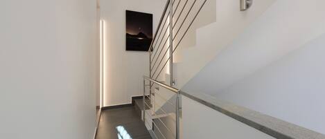 A modern staircase with metal railings and a wall-mounted picture.