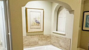 A bedroom with a large bed, a framed picture on the wall, and a window. - Charming 2-bedroom estate in beautiful Williamsburg with WiFi, fitness room (Williamsburg)