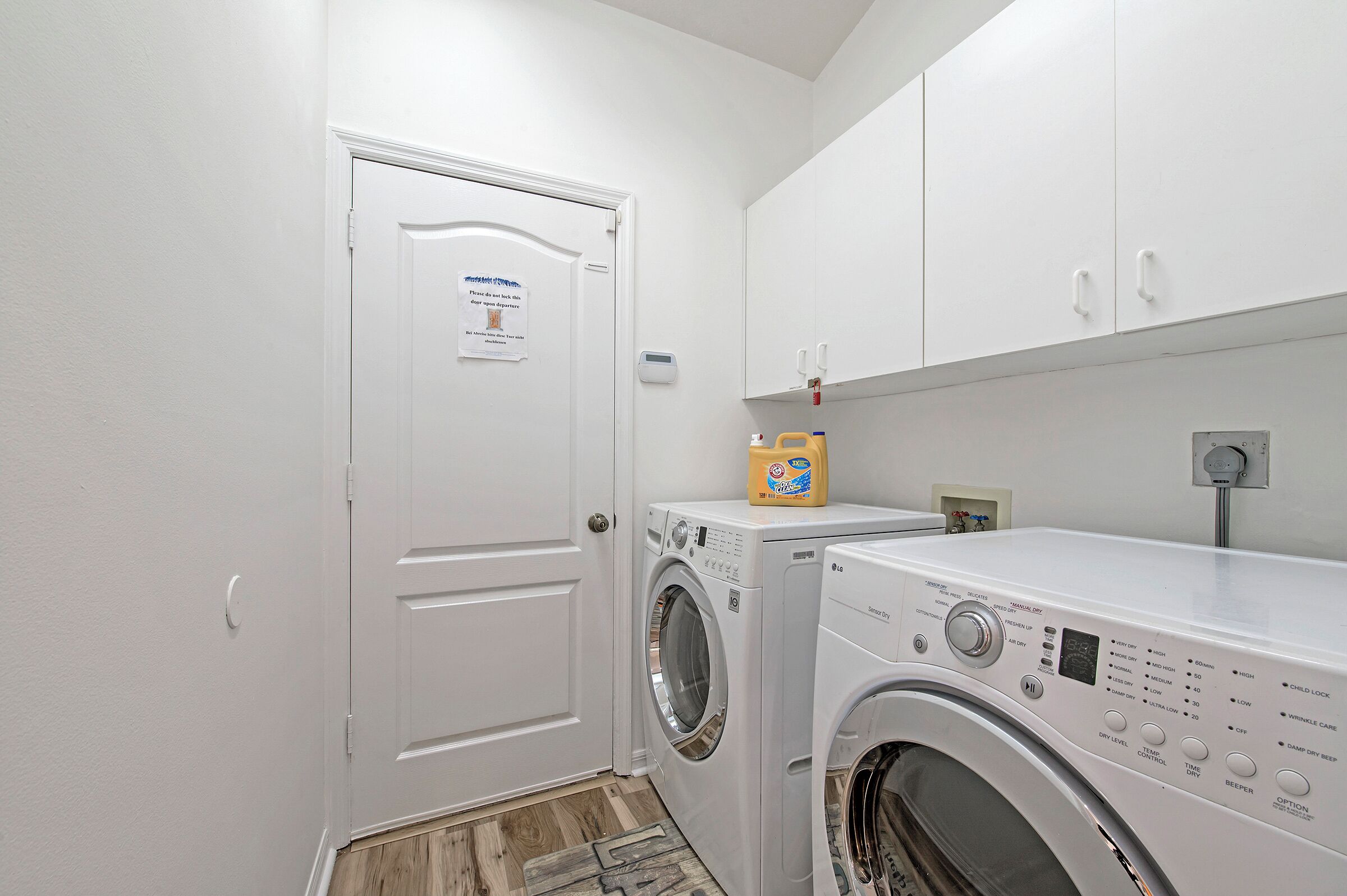 A laundry room with a white door, a washing machine, and a dryer.