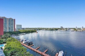 A marina with docked boats, a clear blue sky, and a cityscape in the background. - Le Petit Italie ,Water view 2/2 with pool (Sunny Isles Beach)