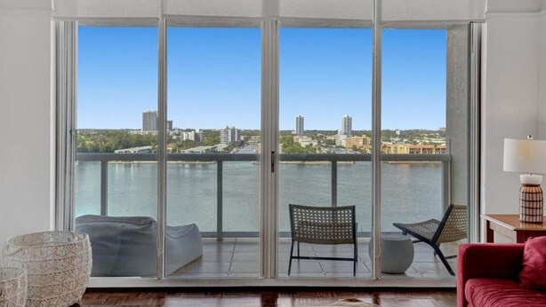 A balcony with a city view, a chair, a sofa, and a lamp.