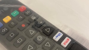 A black remote control with various buttons including a red "Netflix" button, a white "Power" button, and a white "Pause" button. - De Vince Suites   Luxury Rooms   King Executive (Roma)