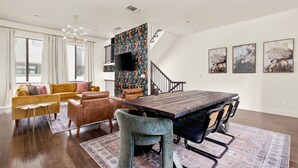A spacious living area with a wooden dining table, leather sofas, and a staircase. - Stylish Pearl District Stay - Relax, Dine & Explore (San Antonio)