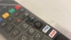 A black remote control with various buttons including a red "Netflix" button, a white "Power" button, and a white "Pause" button. - De Vince Suites   Luxury Rooms   Roma Termini   King De Luxe (Roma)
