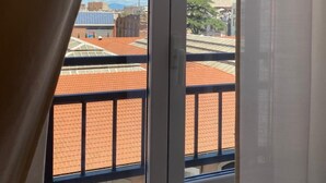 A window with a view of buildings and a clear sky. - De Vince Suites   Luxury Rooms   Roma Termini   King De Luxe (Roma)