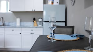 Une table à manger avec deux verres à vin et un set de table, dans une cuisine au décor moderne.