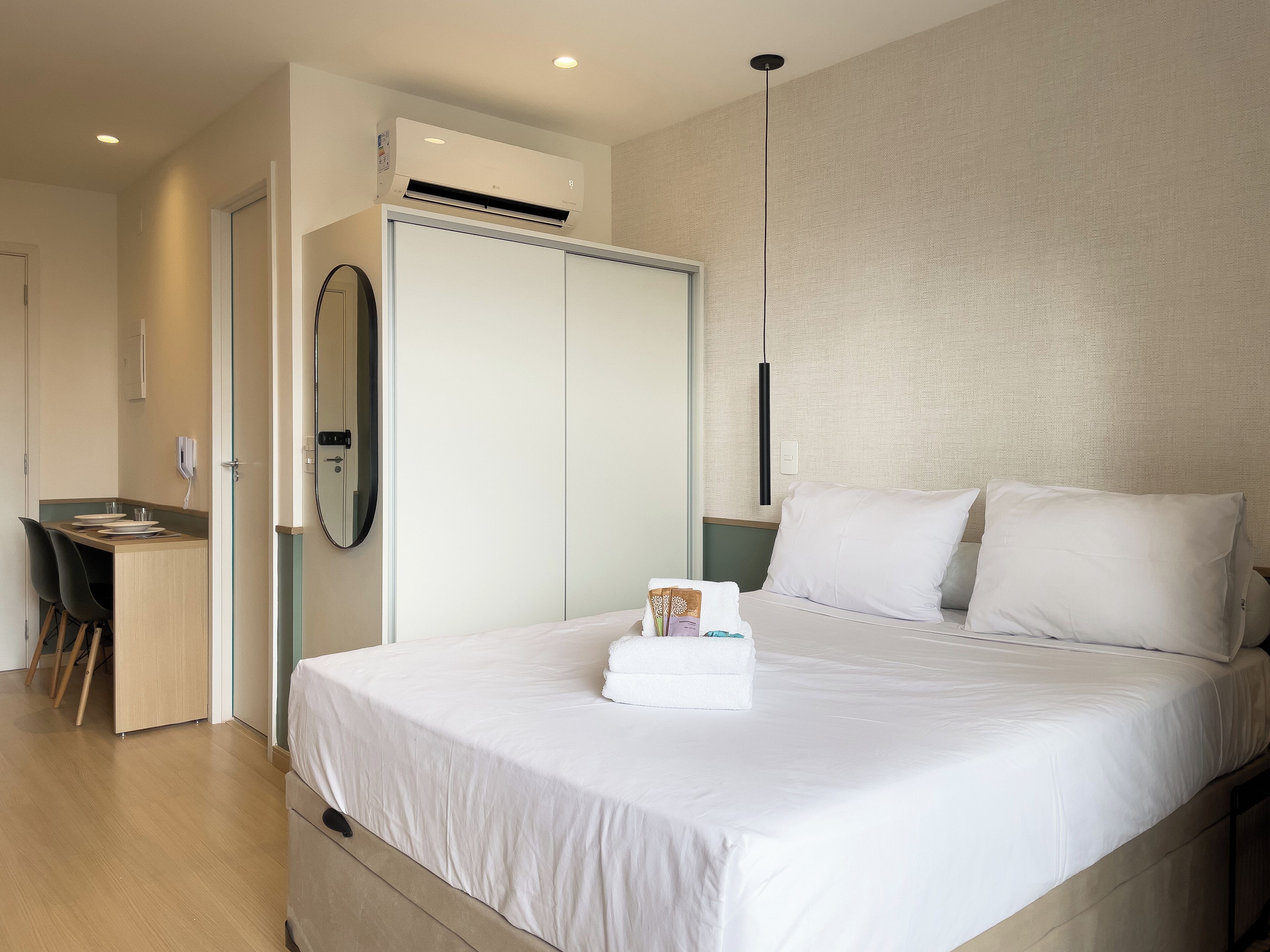 Ein modernes Hotelzimmer mit einem Bett, einem Schreibtisch und einem Kleiderschrank.