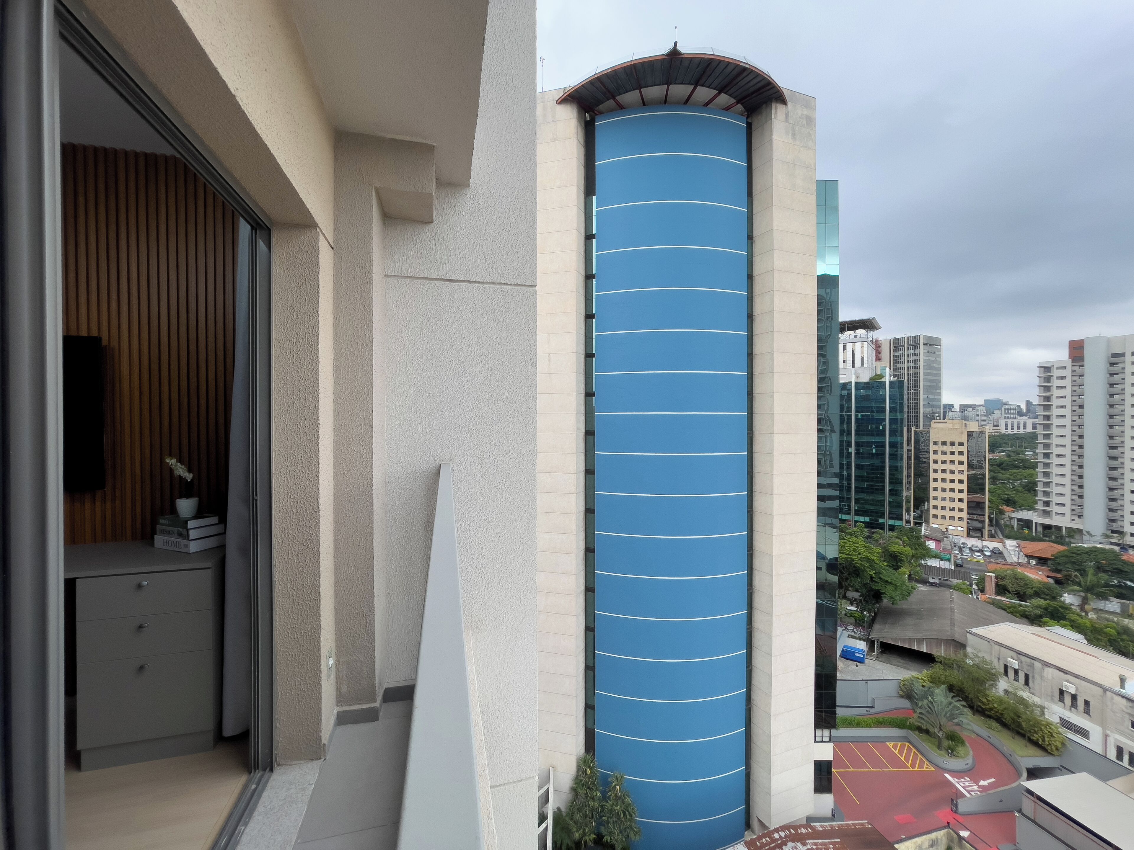 A modern building with a blue cylindrical section and a wooden interior.