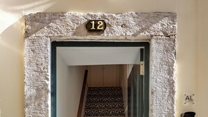 Una scala con piastrelle decorate che conduce a una porta con il numero 12.
