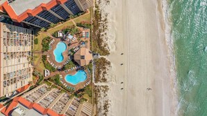 A resort with multiple swimming pools, beach access, and high-rise buildings.