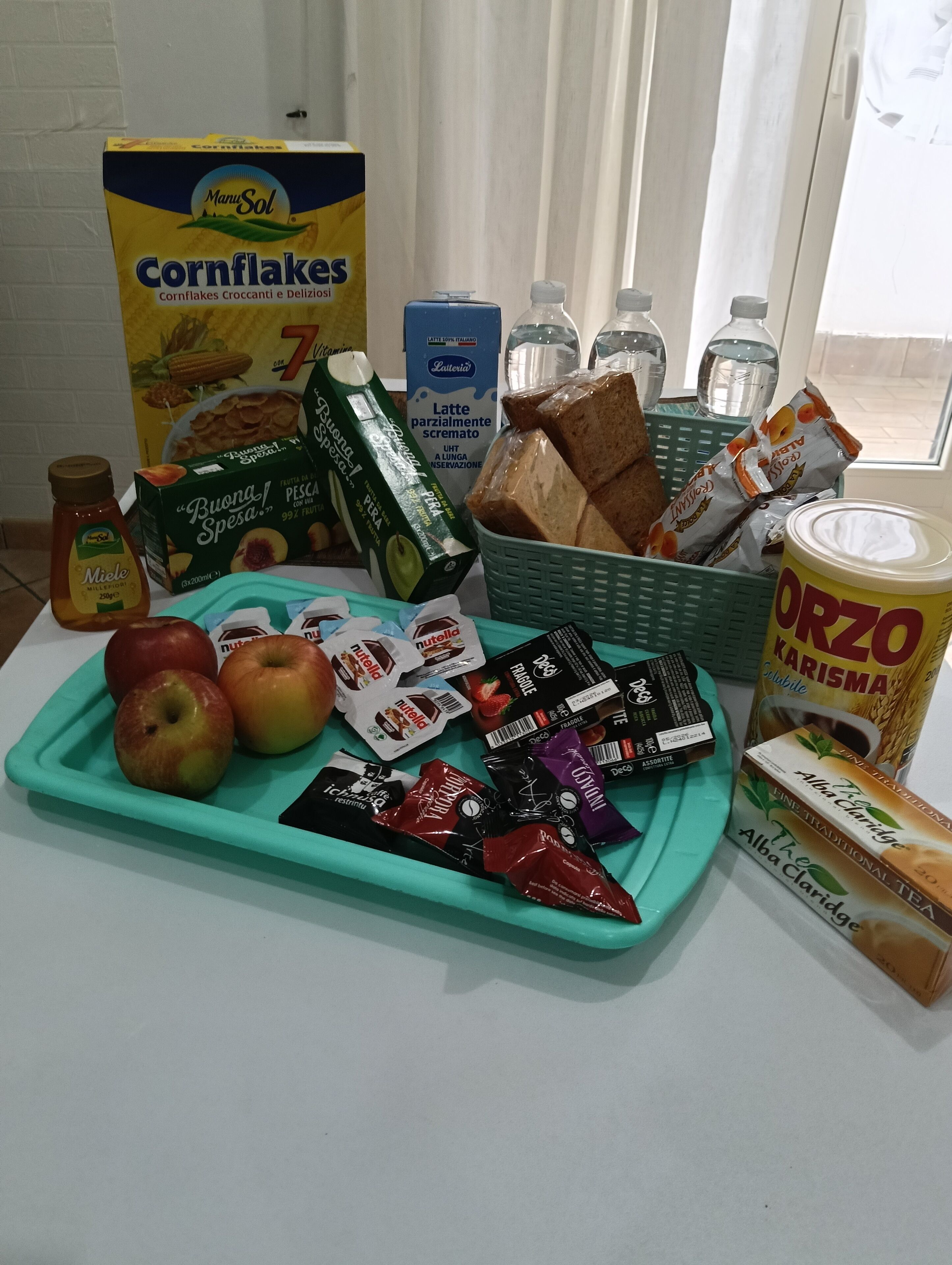 A breakfast tray with apples, Nutella, and cereal.