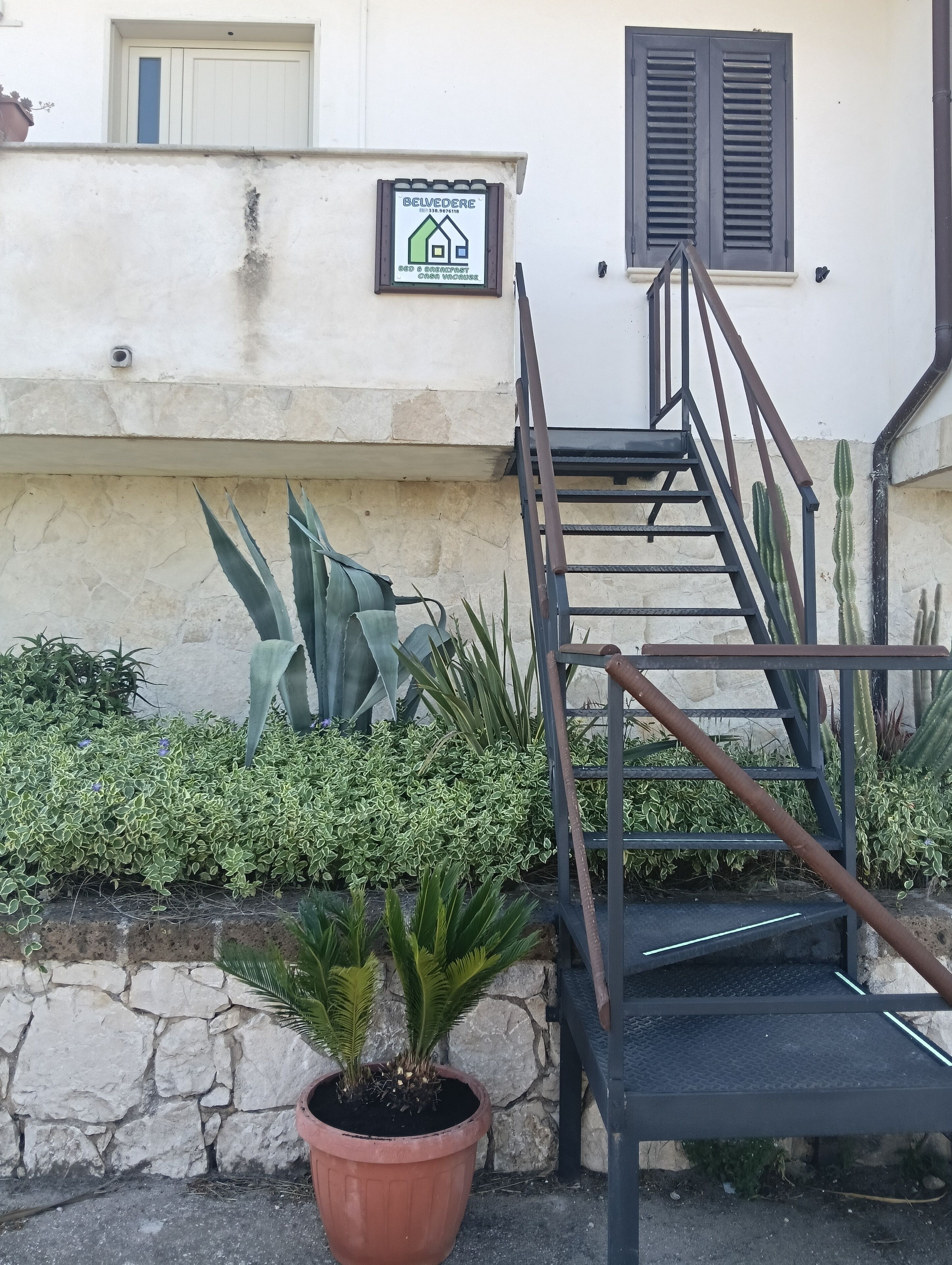 A staircase leading to a building with a signboard.