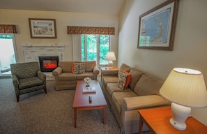 Deluxe suite, 2 slaapkamers | Woonruimte | Een 32-inch flatscreentelevisie met satellietzenders en een open haard