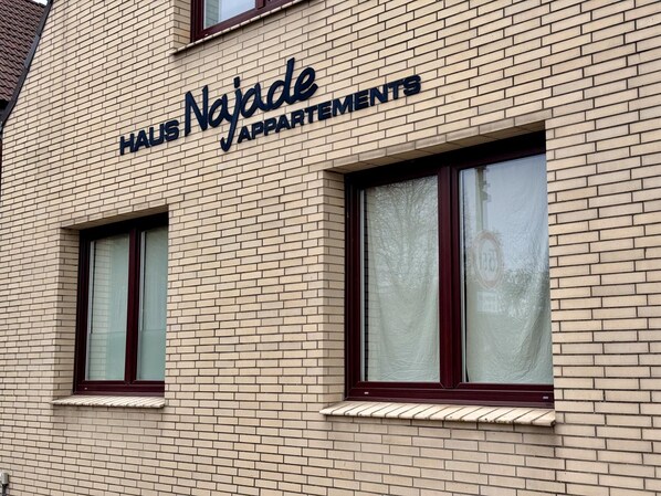 A building with a sign reading 'HAUS Najade APARTMENTS'. - House Najade, small feel-good oasis Whg. 7, Pastoratsweg 17, 27476 Cuxhaven Döse (Cuxhaven)