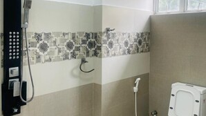 A bathroom with a shower, toilet, and a wall-mounted control panel. - Hotel Ceylonia Colombo (Colombo)