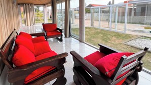 A modern interior with wooden ceiling and large glass windows.