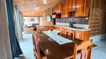 Una cocina con paneles de madera, una isla central, armarios de madera y piso de baldosas.