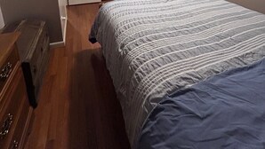 A bedroom with a bed, dresser, and a television on the wall. - Charming 3-bedroom house in Mountain City beautiful big coy pond in backyard (Mountain City)