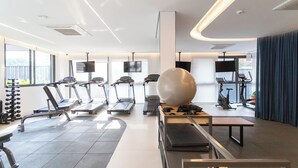 A modern gym with treadmills, elliptical machines, and free weights. - Co.Next Liberdade (Sao Paulo)