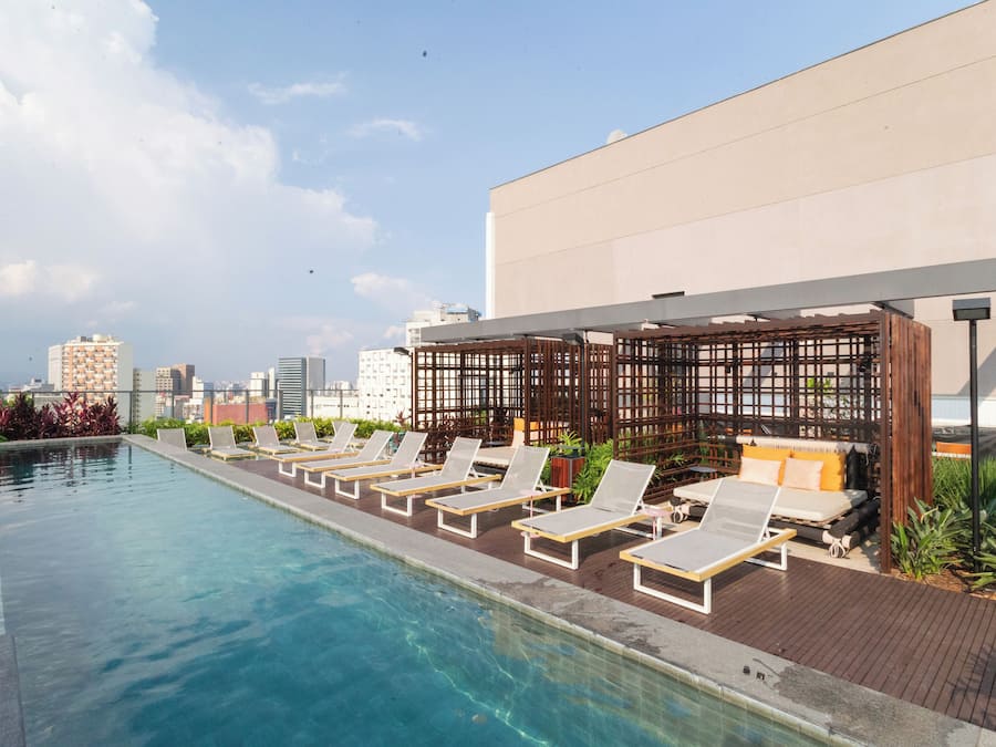 Una piscina al aire libre, sillones reclinables de piscina