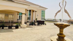 A building with a fountain in front. - Amazon Luxury Apartment (Enugu)