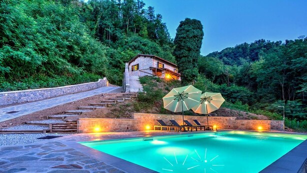 A swimming pool with a stone deck, surrounded by a stone wall and steps leading up to a lodge. - Tuscan villa for 8 people with pool near Lucca. (Borgo a Mozzano)