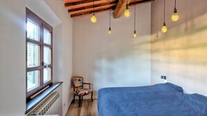 A bedroom with a wooden ceiling, a bed, a chair, and a window. - Tuscan villa for 8 people with pool near Lucca. (Borgo a Mozzano)