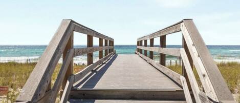 Un paseo marítimo de madera que lleva a la playa.