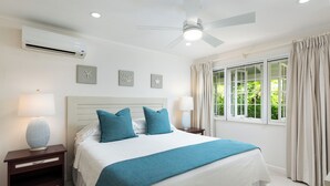 A bedroom with a bed, nightstands, a ceiling fan, and a window with curtains. - Charming 2-bedroom condo in fabulous Hastings area (Hastings)