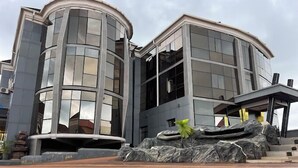 A modern building with a curved facade and large windows. - Infinite Luxury Hotels and Suites (Enugu)