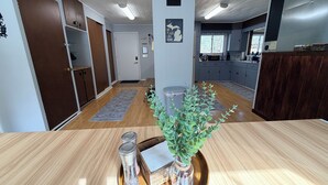 A modern kitchen with grey cabinets, a wooden countertop, and a view to the dining area.