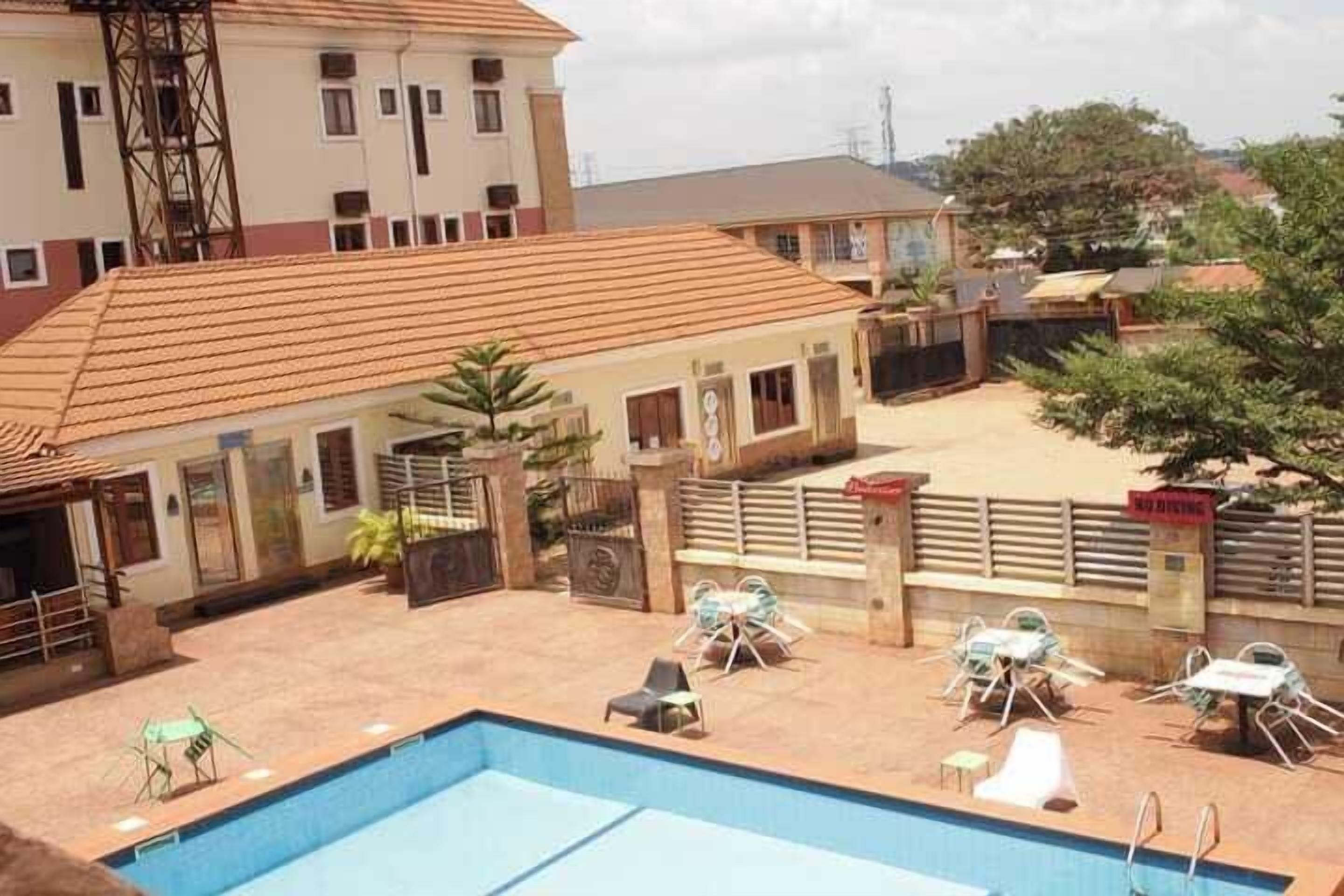 Piscina com espreguiçadeiras e um pátio cercado.