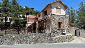 A two-story building with a stone facade and a red-tiled roof. - VILLA AURA (Πλάτρες)