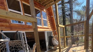 A wooden cabin with a wooden deck, a hammock, and a hanging chair. - Cabin in the TreeTops! 4 Level a-frame cabin, with 5 levels of decks (Lancaster)