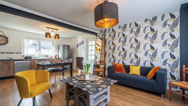 A modern living room with a sofa, yellow armchair, and a coffee table with a floral pattern. - Le Jovia - Cour extérieure - Wifi (Laval)