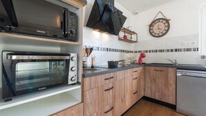 A modern kitchen with a built-in oven, microwave, and dishwasher. - Le Jovia - Cour extérieure - Wifi (Laval)