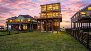 A waterfront property with multiple levels, a deck, and a grassy area. - Beachfront | Hot Tub | Putt Putt | Fire Pit (Gilchrist)