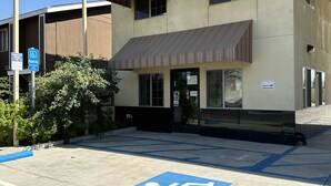 A building with a sign reading "Corcoran Inn" and a blue handicap parking sign. - Corcoran Inn (Corcoran)