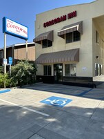 Un bâtiment sur lequel on peut lire l’inscription « Corcoran Inn » et où se trouve un panneau bleu indiquant une place de stationnement réservée aux personnes handicapées.