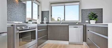 A modern kitchen with built-in appliances, a window, and a view of the outside.