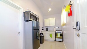 A compact kitchen with a refrigerator, microwave, stove, and cabinets. - Beautiful 1-bedroom apartment in amazing Buckleys with AC, WiFi (Buckleys)